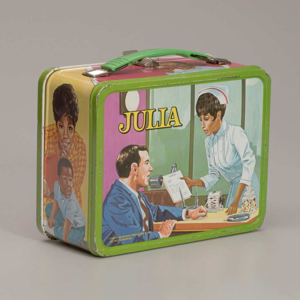 A photo of the back of a vintage Julia themed lunchbox